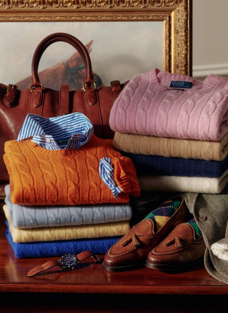 Stacked folded cable-knit sweaters in various hues.