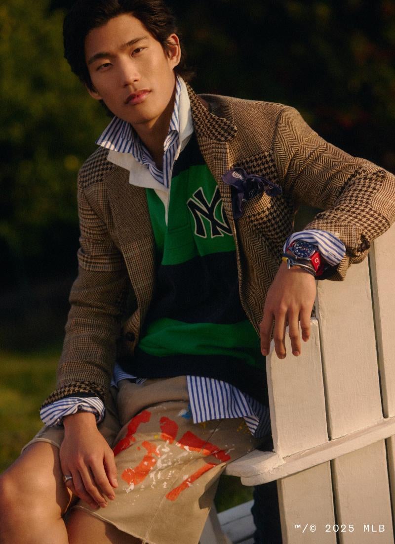 Man wears tweed blazer over striped Yankees rugby shirt.