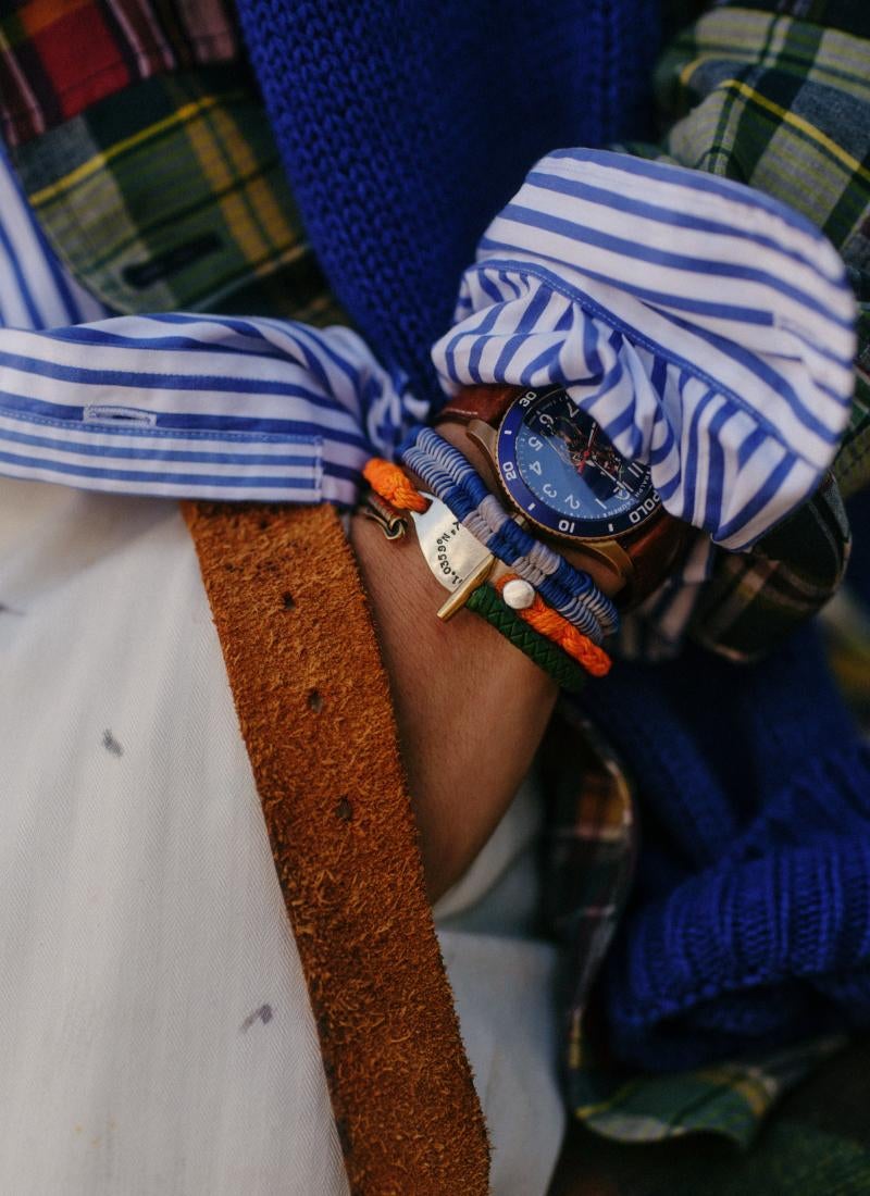 Close-up of man’s wrist with bracelets and watch.
