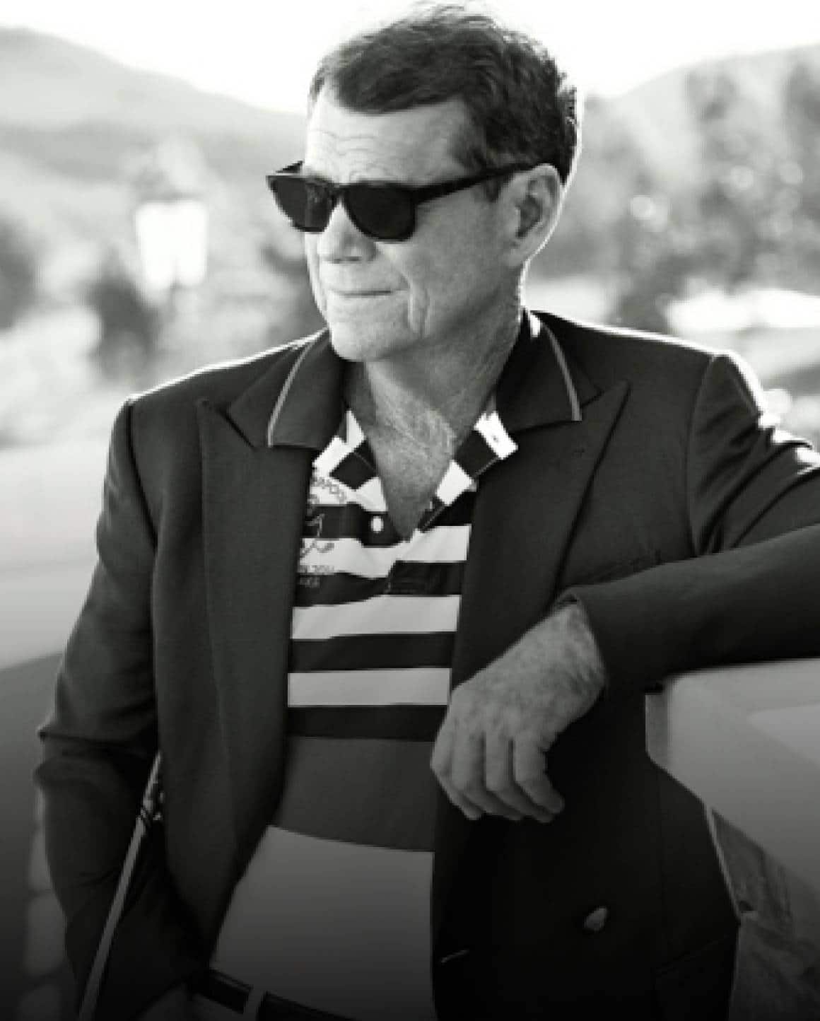 Black-and-white photo of Tom Watson in blazer and striped Polo shirt.