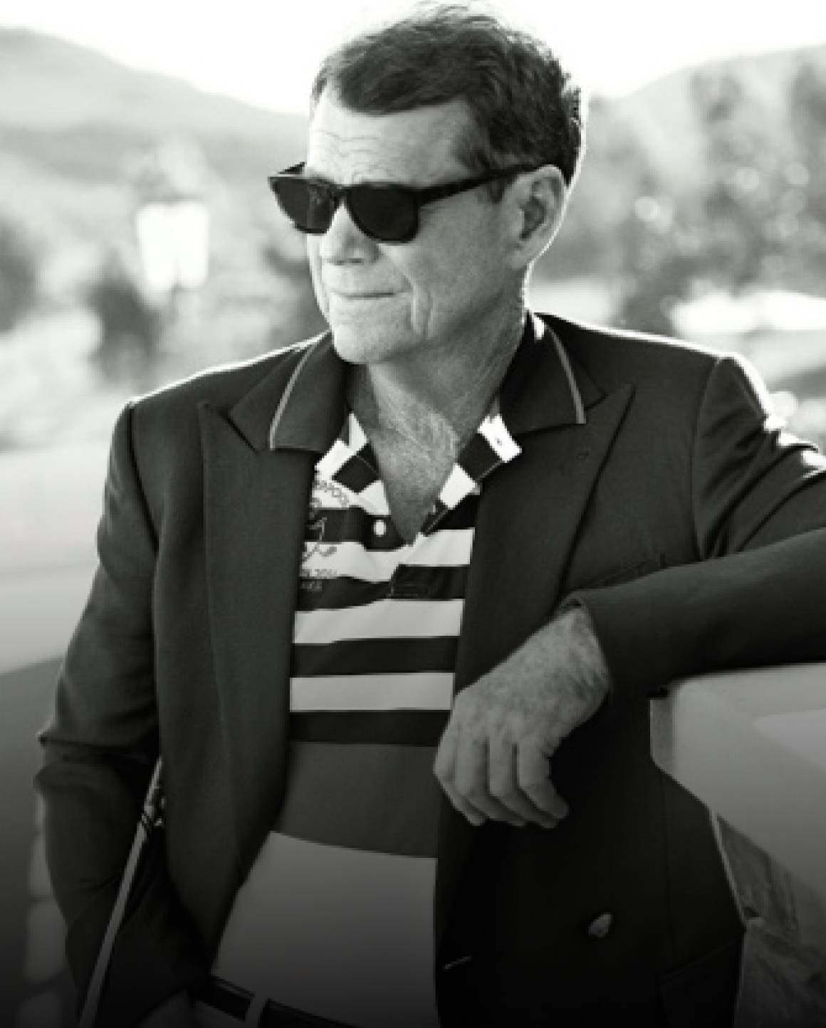 Black-and-white photo of Tom Watson in blazer and striped Polo shirt.