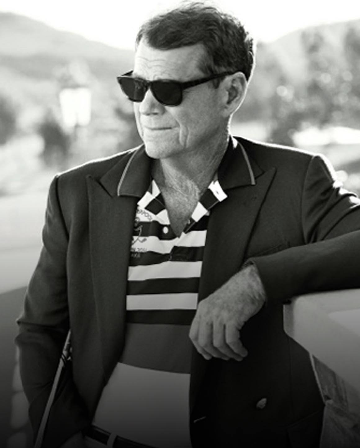 Black-and-white photo of Tom Watson in blazer and striped Polo shirt.
